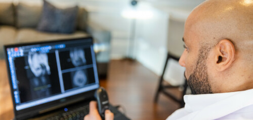 Black Male Radiologist Doctor Reading X ray Images on Laptop from Home